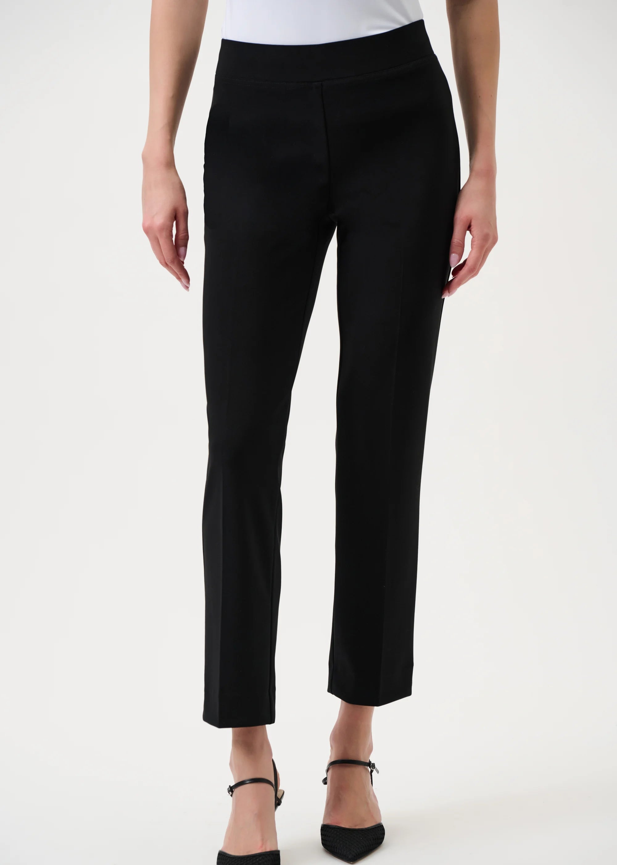 Black pants worn by a person on a white background