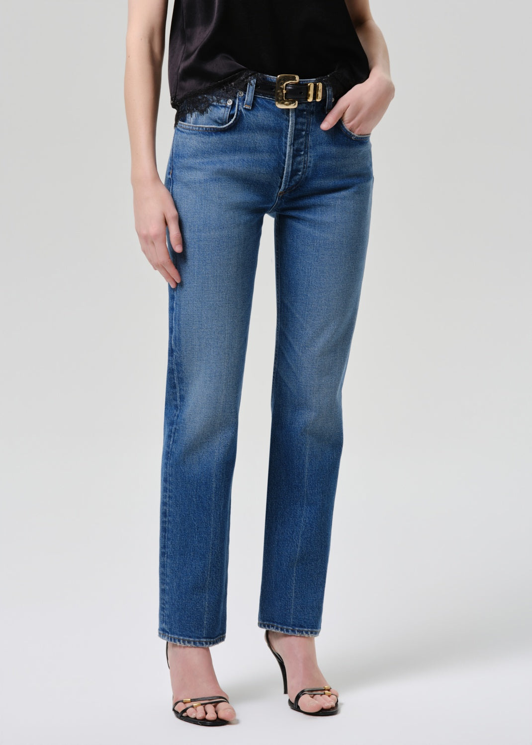 Person wearing blue jeans on a plain background