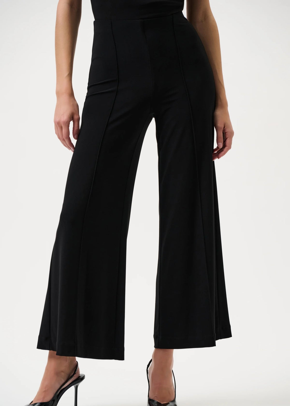 Black wide-leg pants worn by a person on a white background