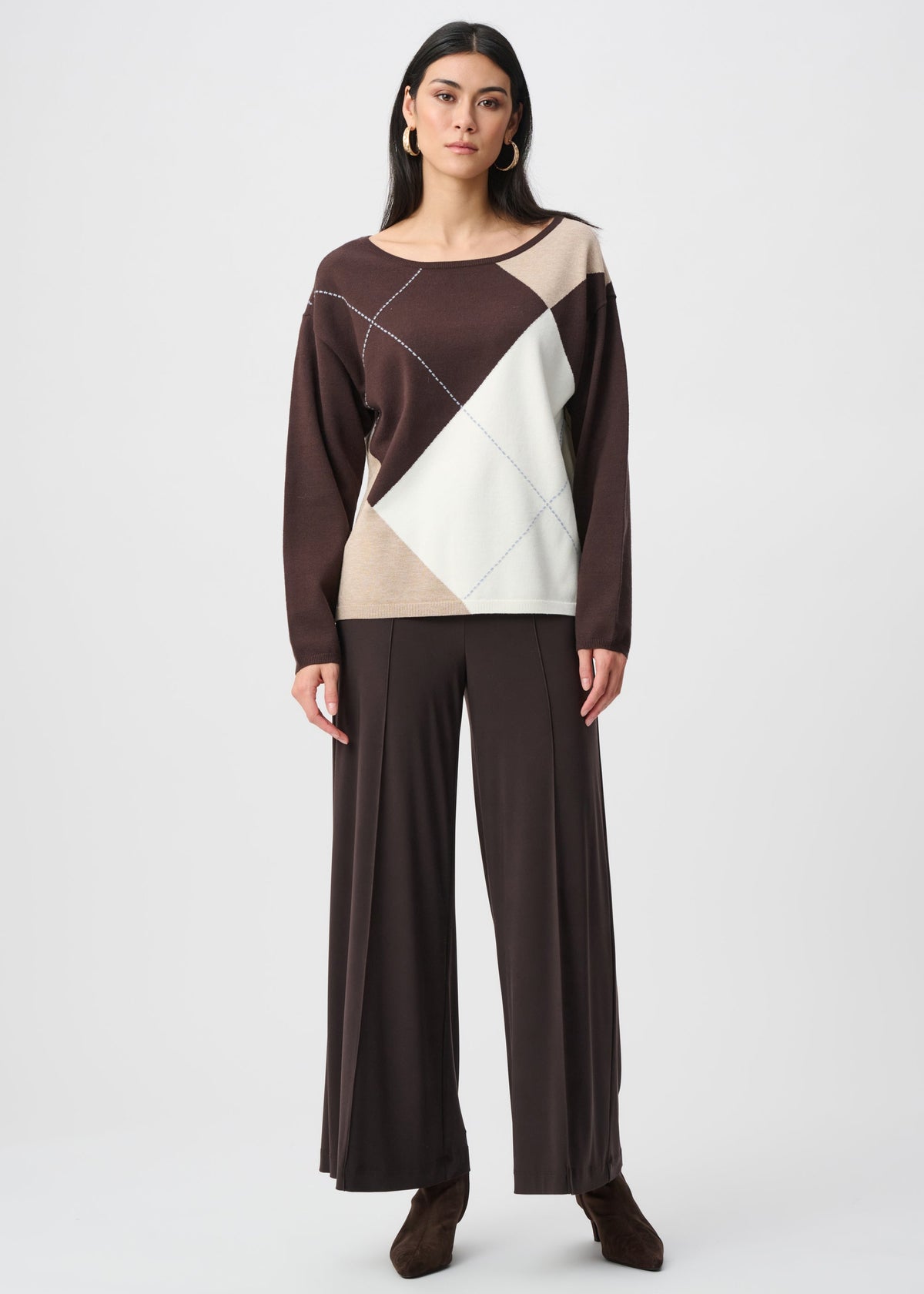 Woman wearing a brown and beige geometric-patterned top with wide-leg pants on a white background