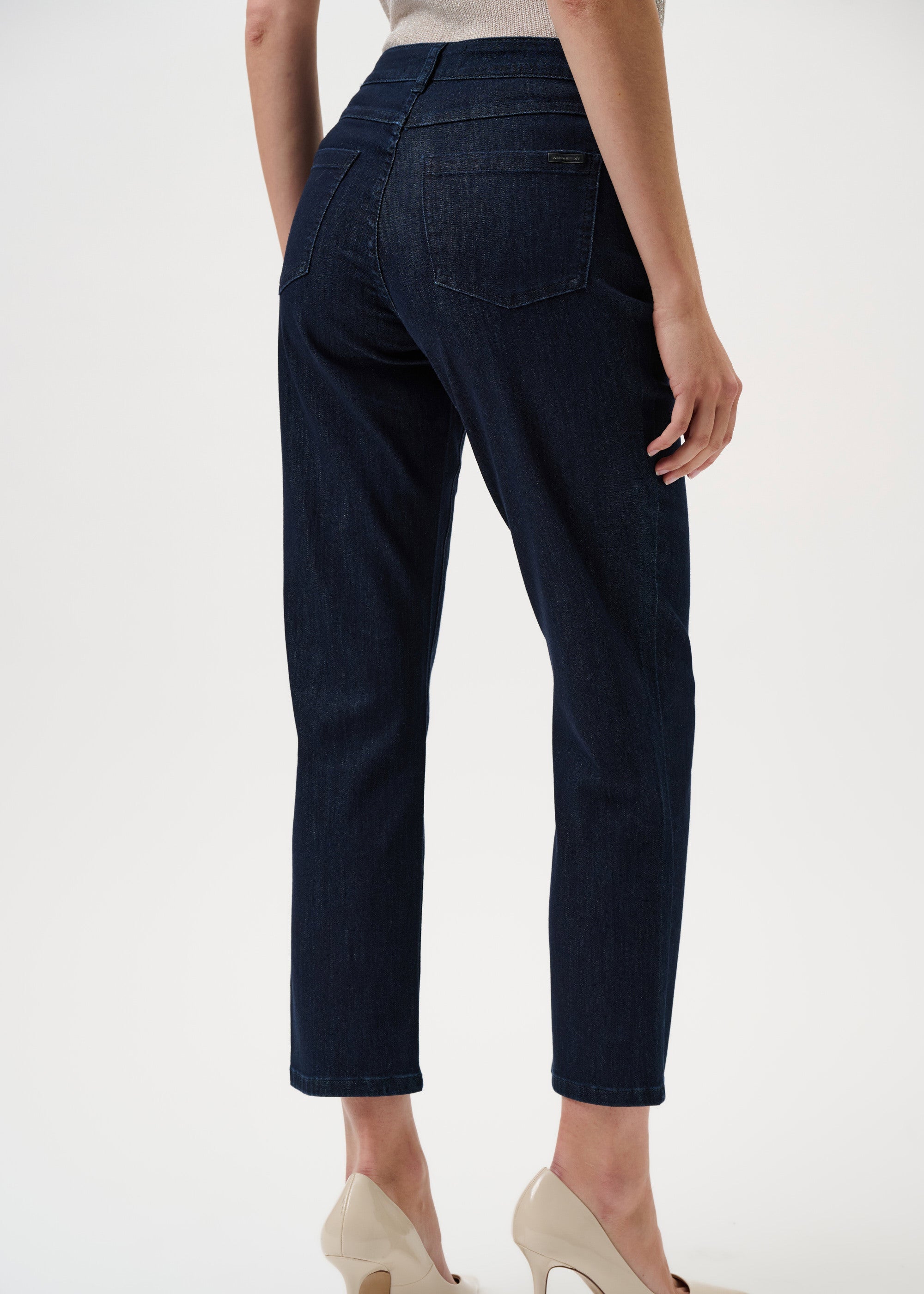 Dark blue pants worn by a person on a white background