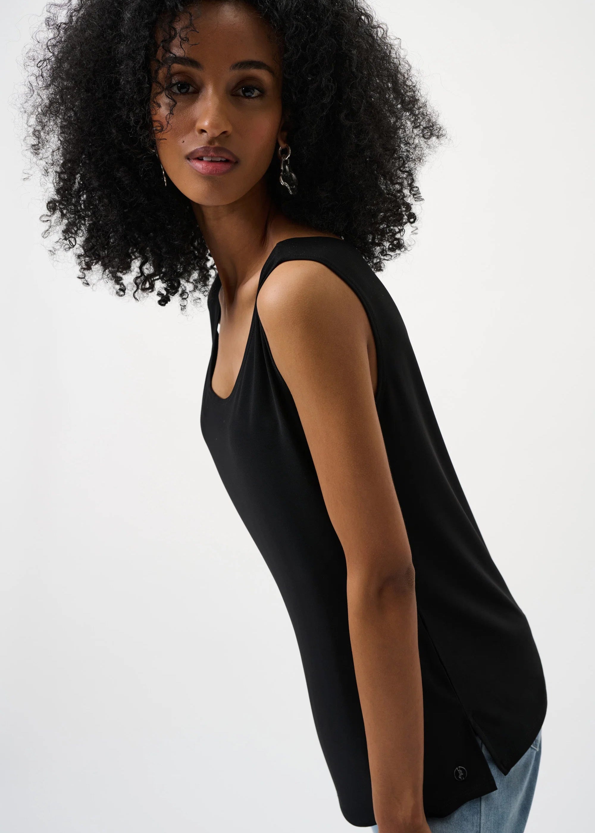 Woman wearing a black sleeveless top against a white background
