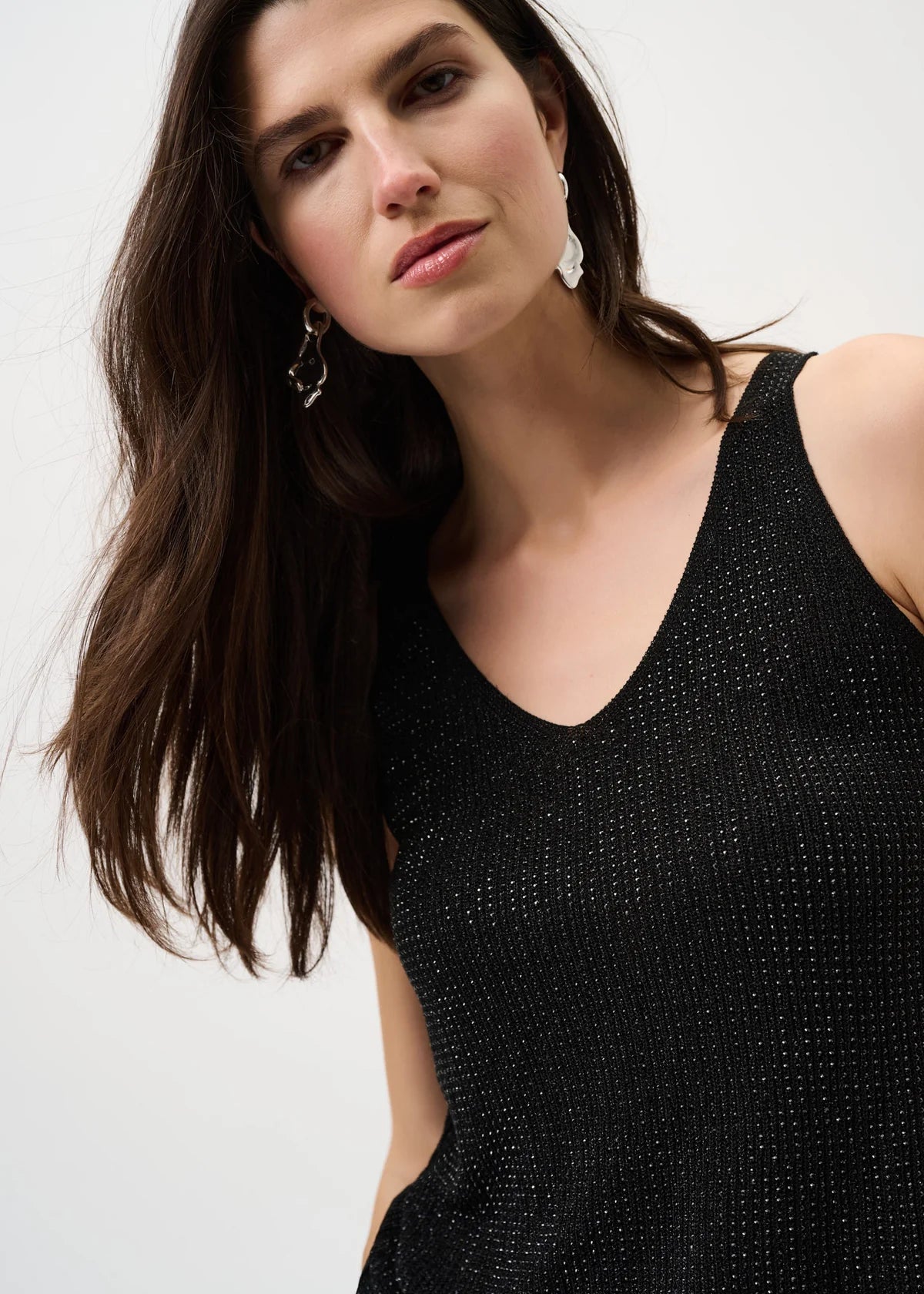 Woman wearing a black sleeveless top against a white background