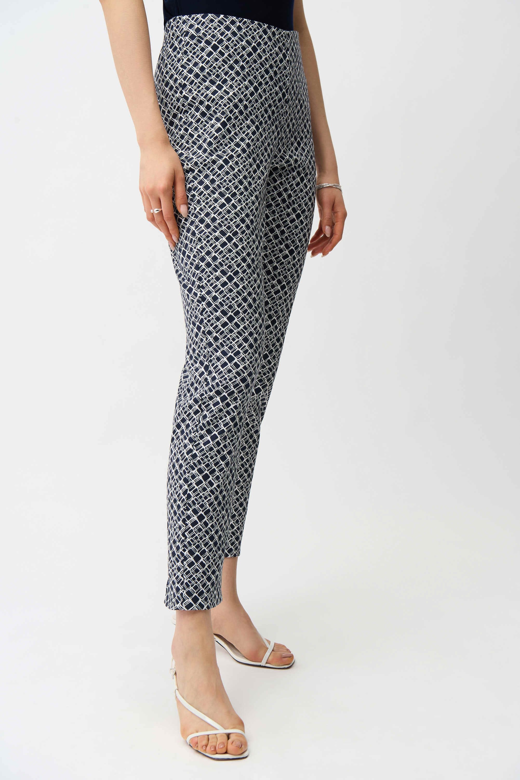 Person wearing black and white patterned pants on a white background