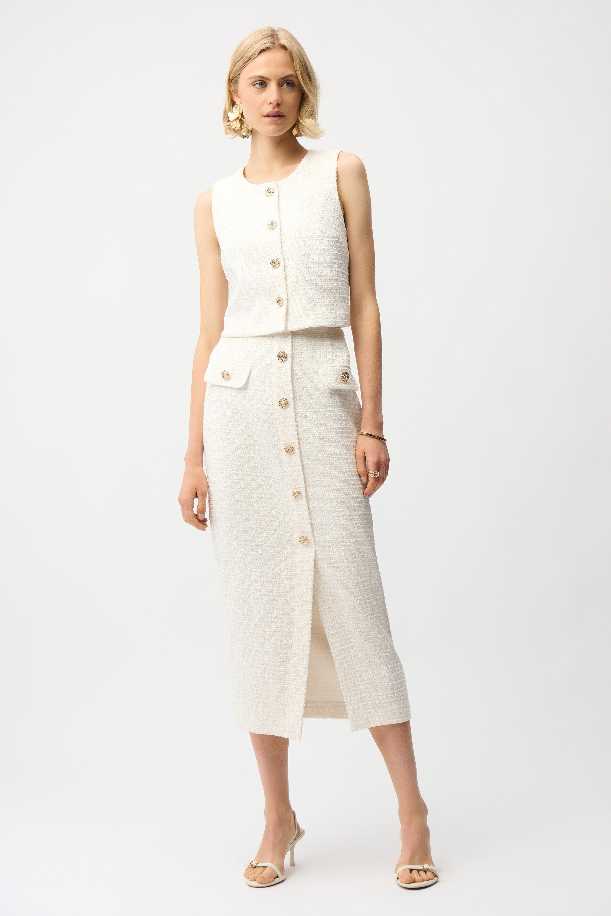 Woman wearing a white sleeveless top and pants set on a white background