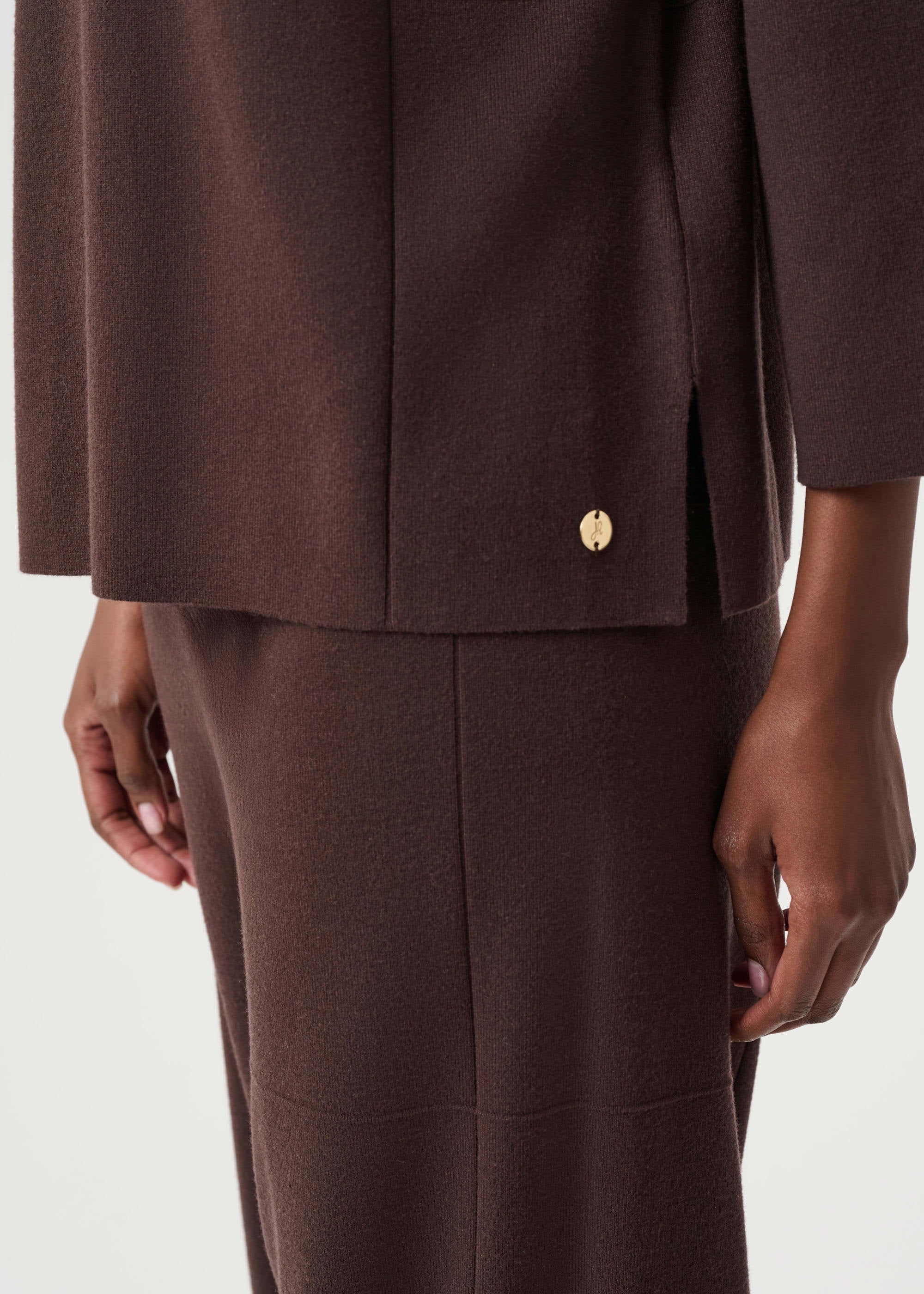 Brown suit with a gold button on a white background