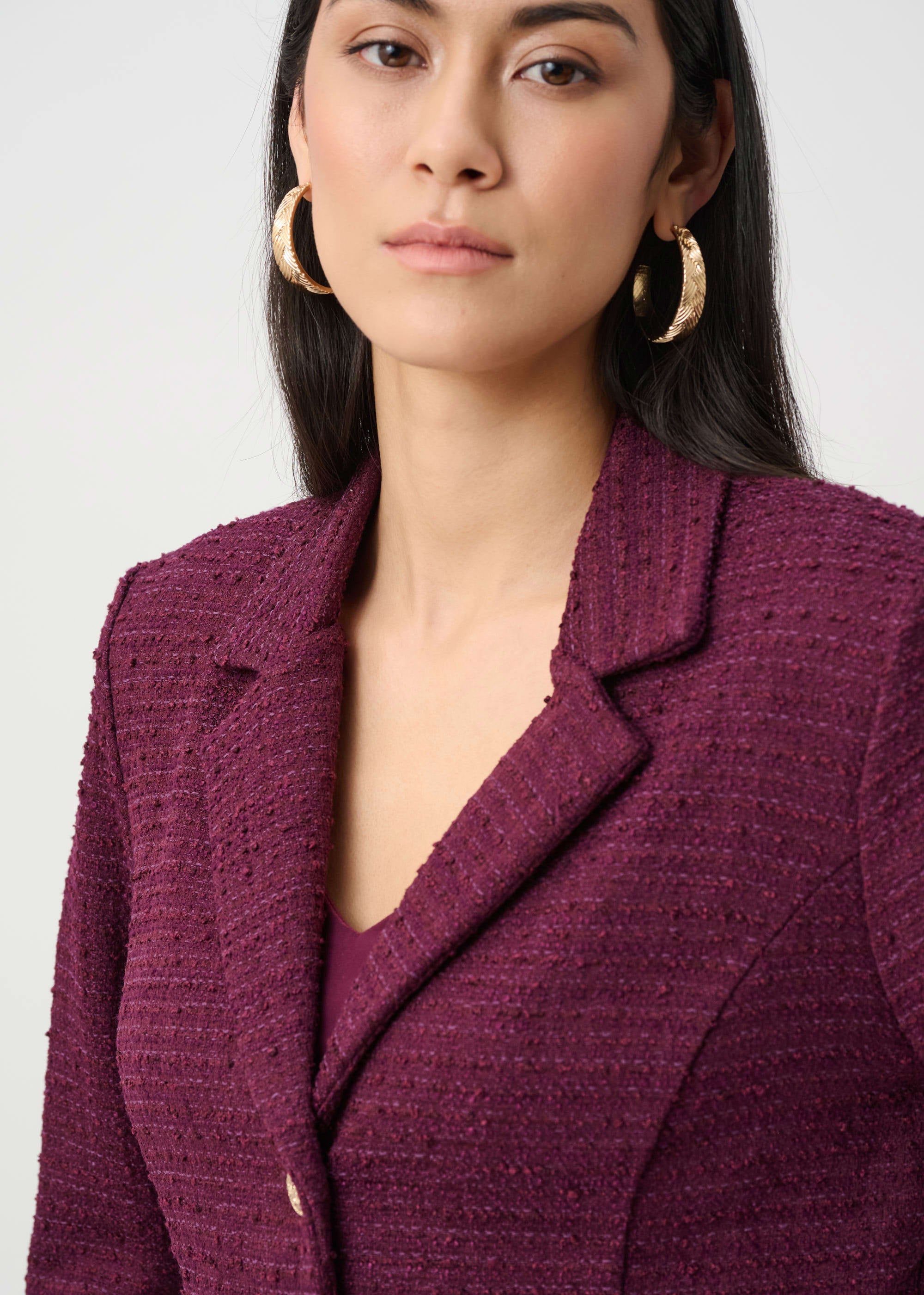 Woman wearing a purple blazer against a plain background