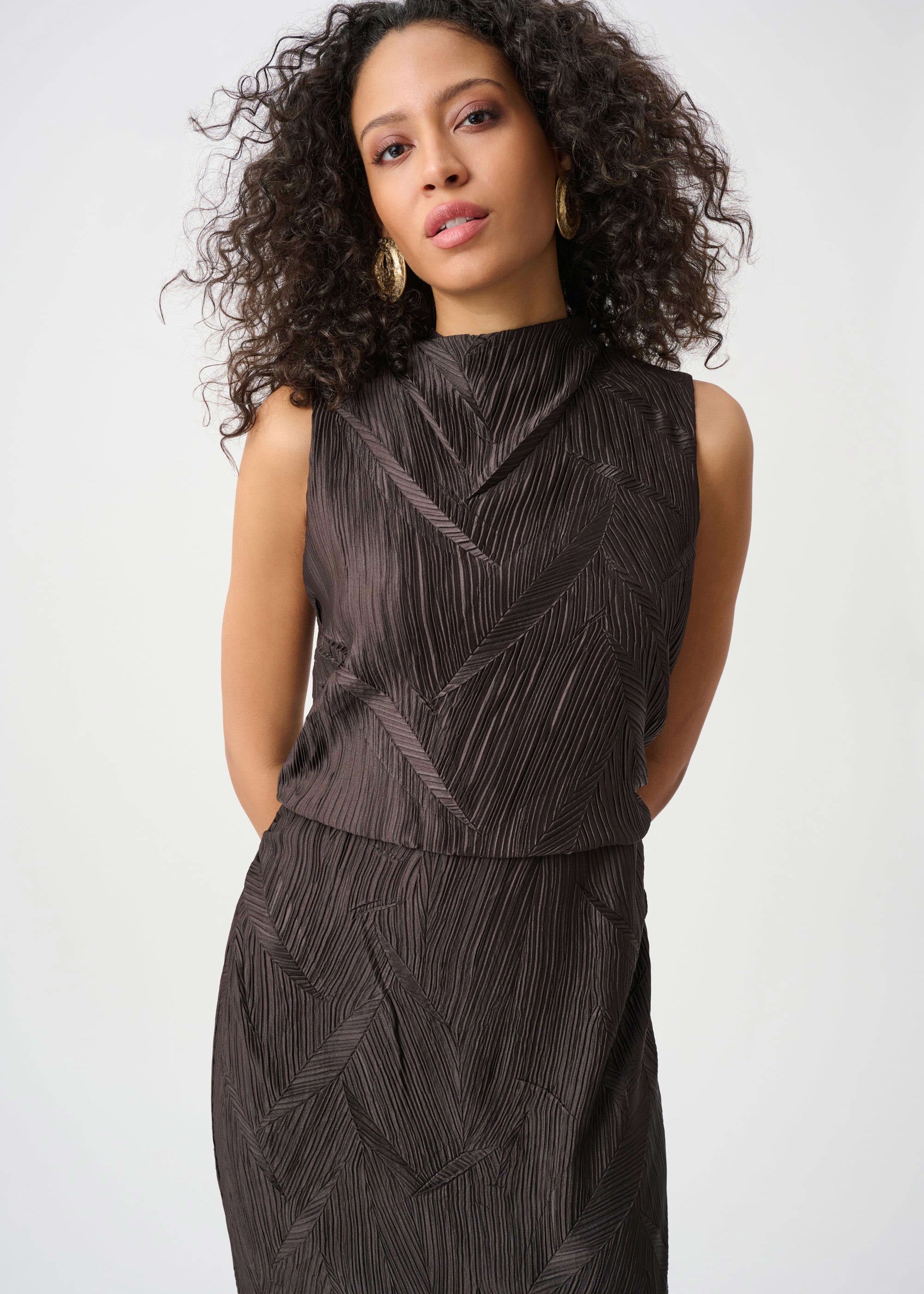 Woman wearing a dark gray textured dress against a white background