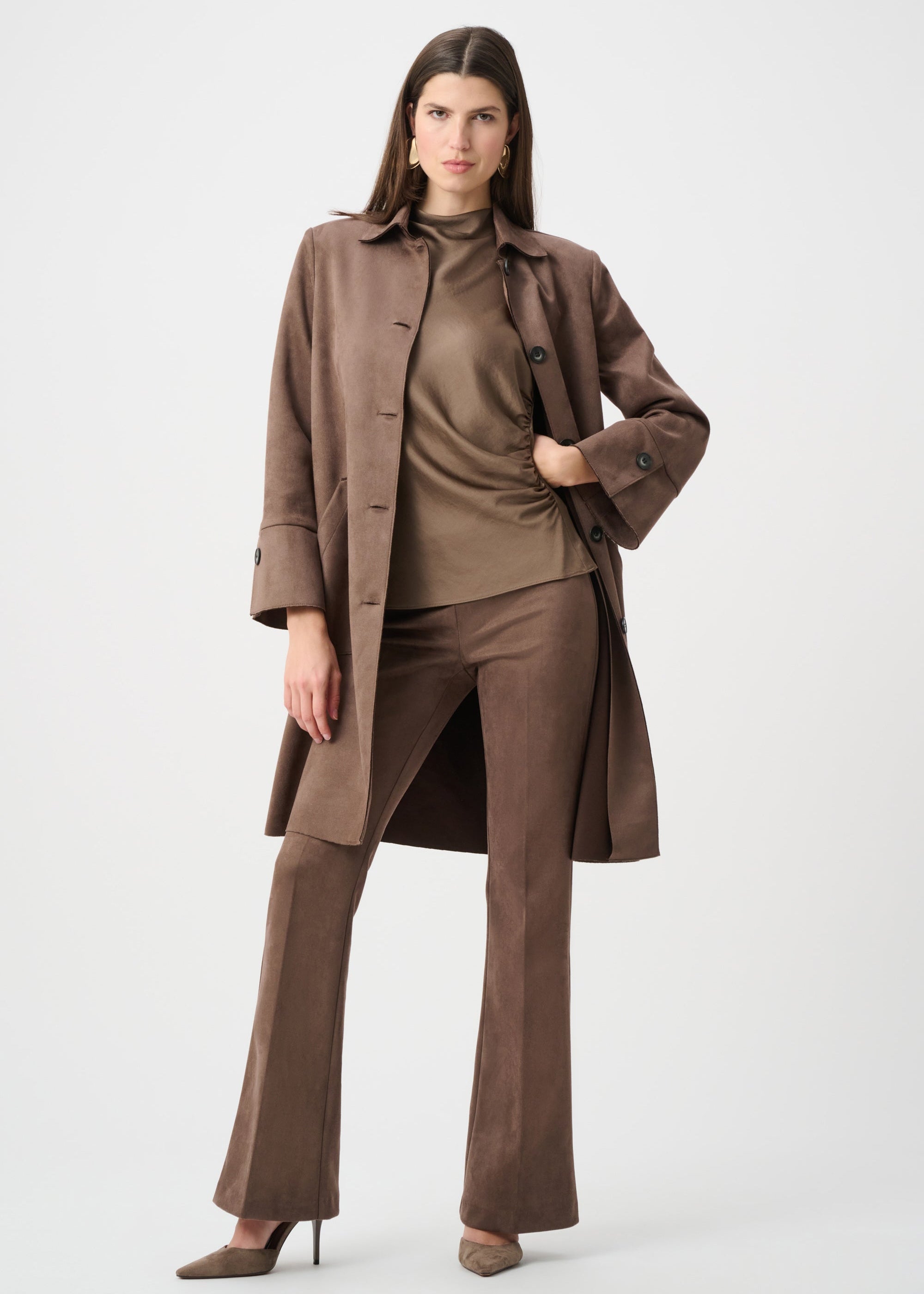Woman wearing a brown coat and pants on a white background