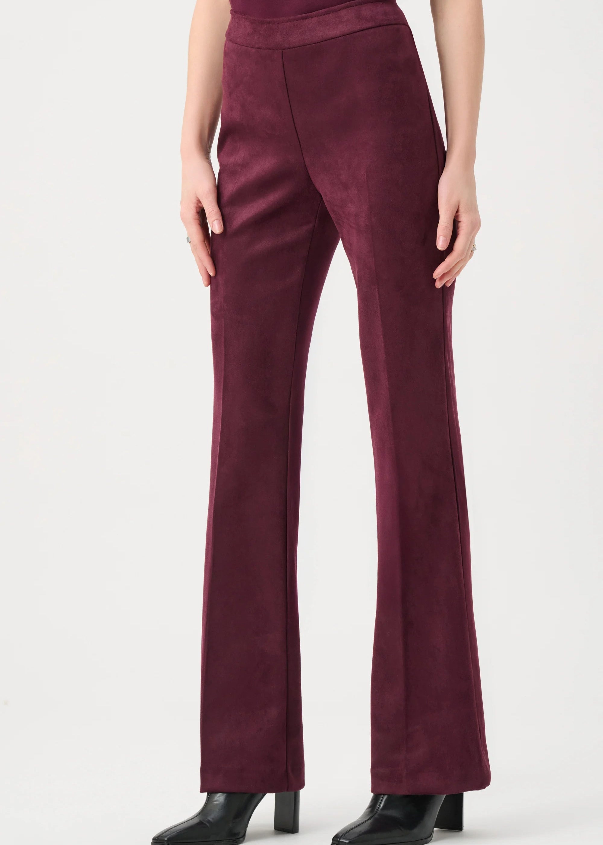 Maroon pants worn by a person on a white background