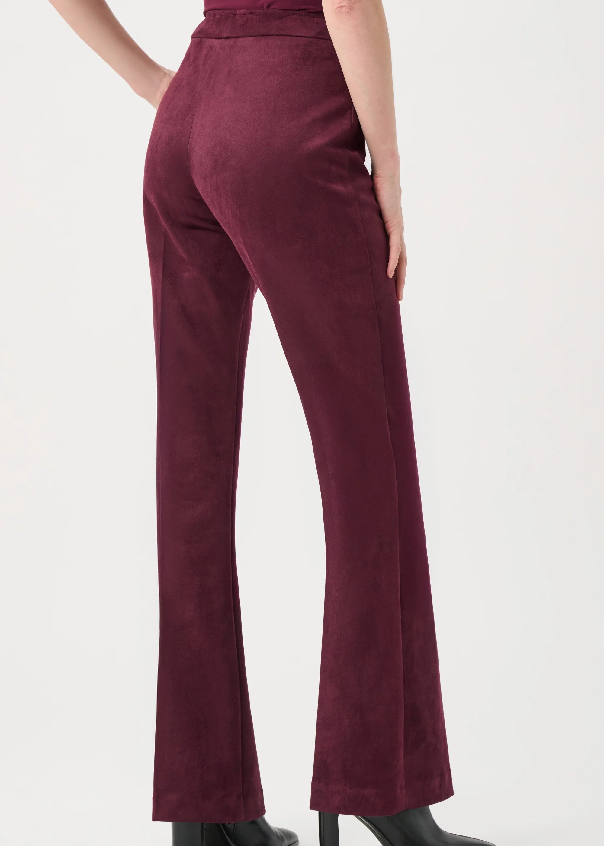 Maroon pants worn by a person on a white background