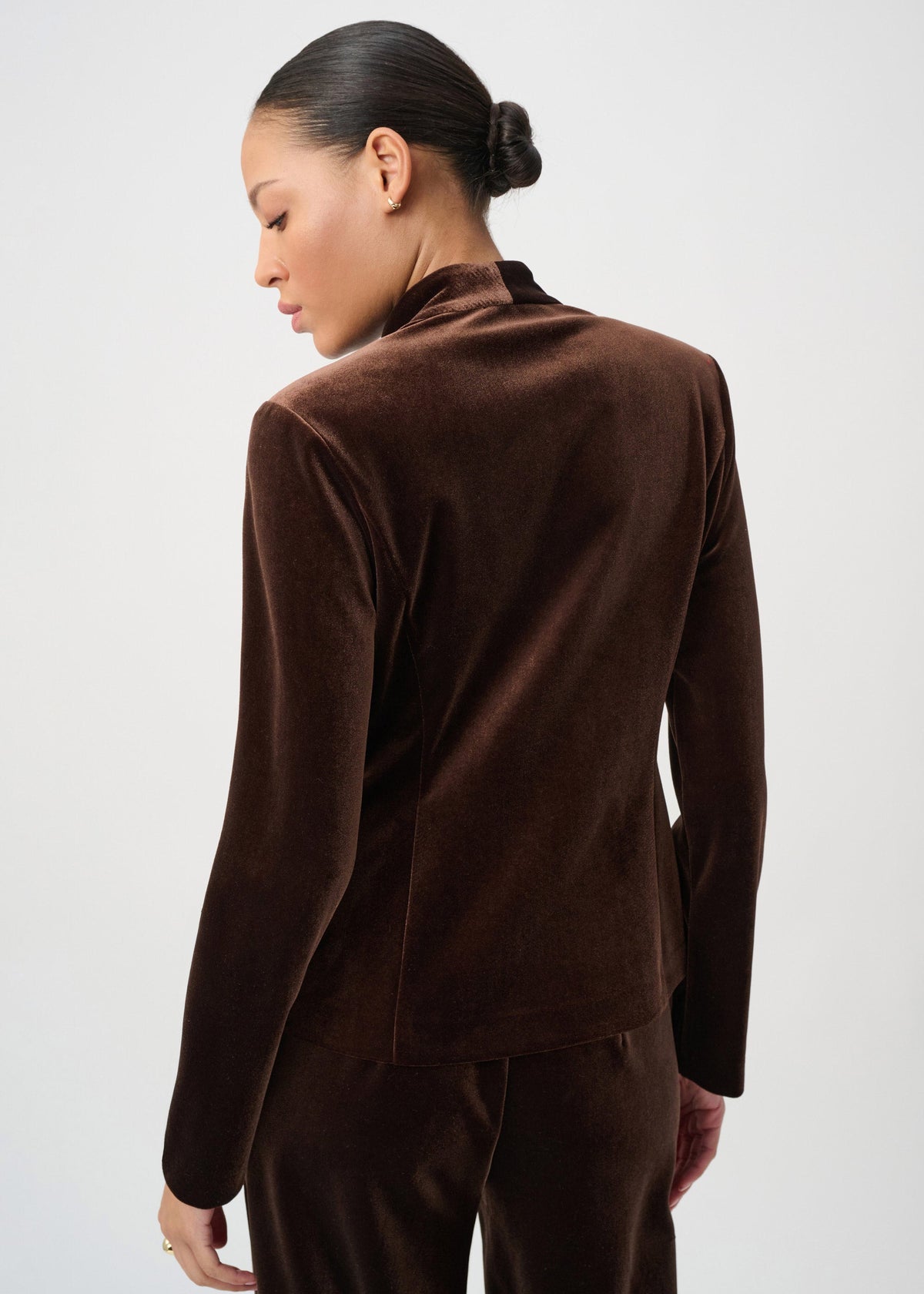 Woman wearing a brown velvet outfit against a white background