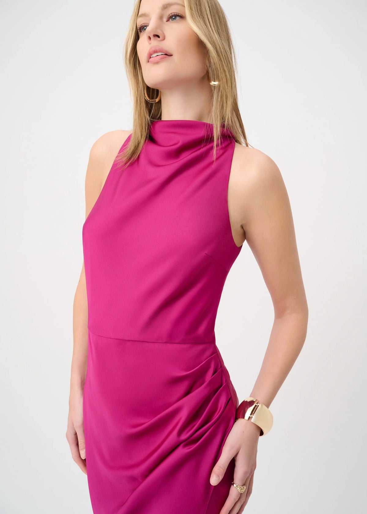 Woman wearing a bright pink sleeveless dress on a white background