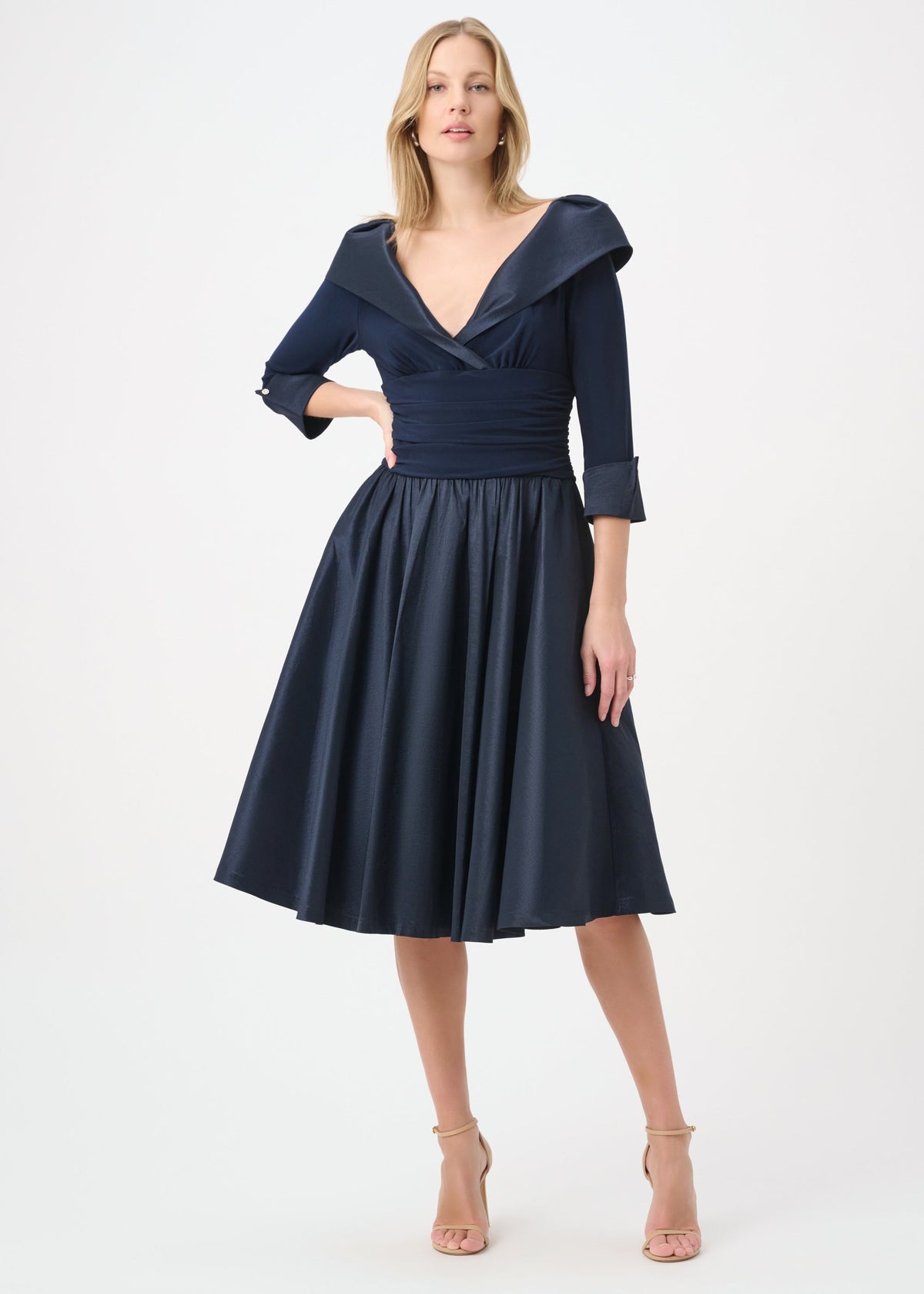 Woman wearing a navy blue dress with a white background
