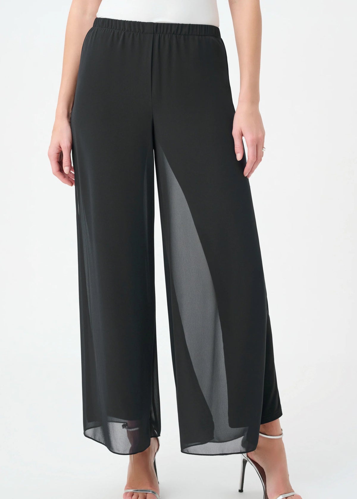 Black wide-leg sheer chiffon pants with an elastic waistband, modeled with silver high-heeled sandals against a plain white background.