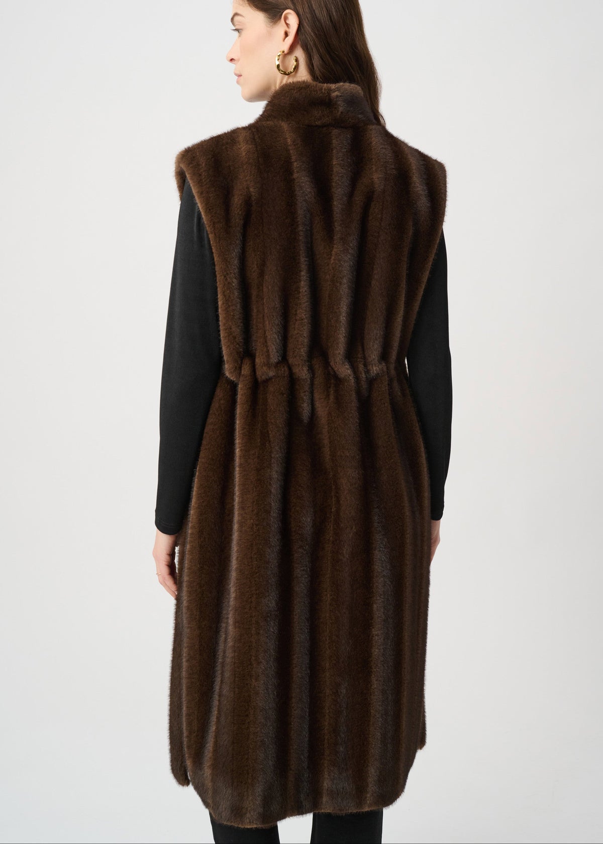 Woman wearing a brown fur vest on a white background