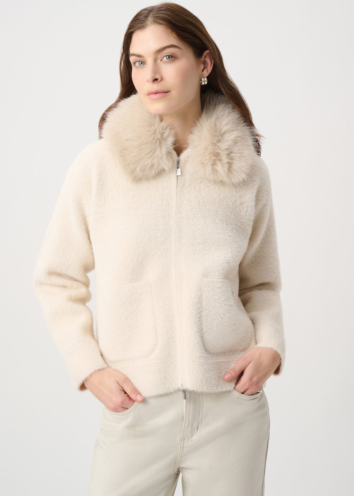 Woman wearing a cream-colored jacket with fur collar on a white background