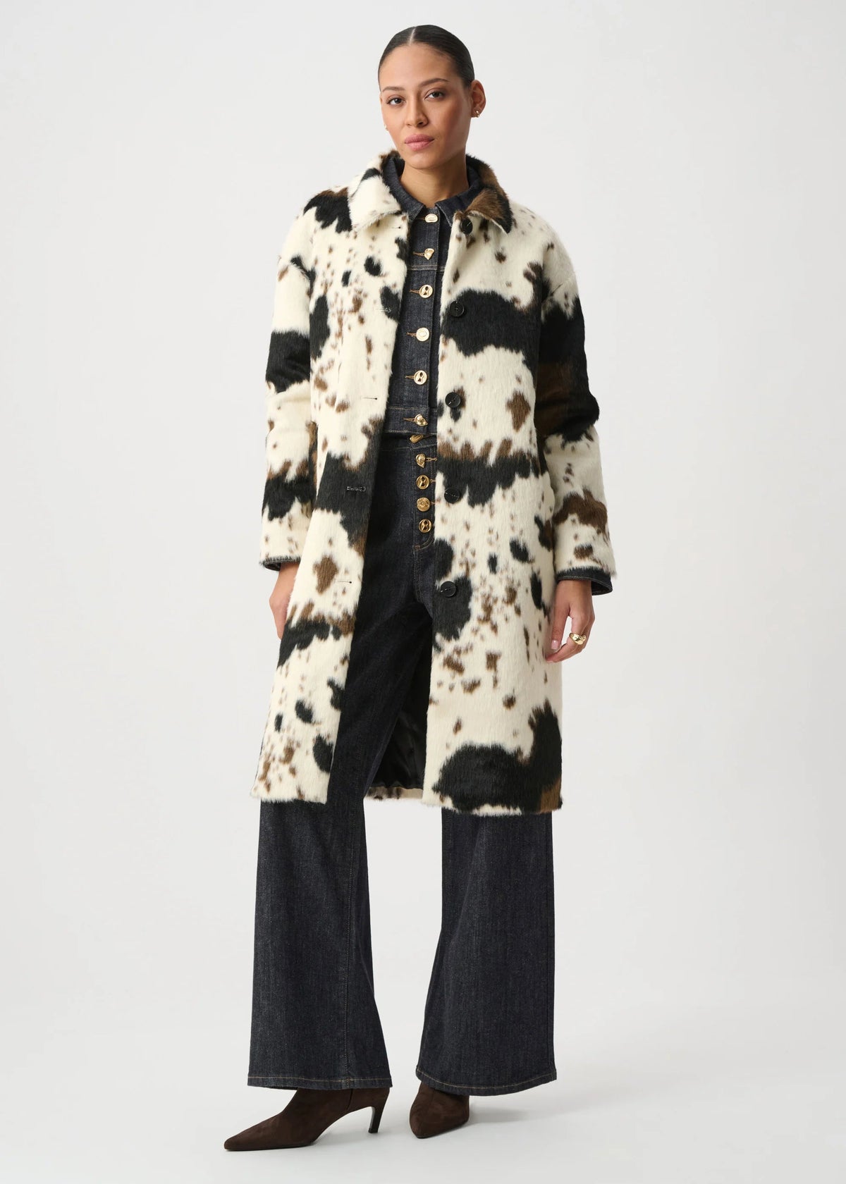 Person wearing a long, patterned coat on a white background