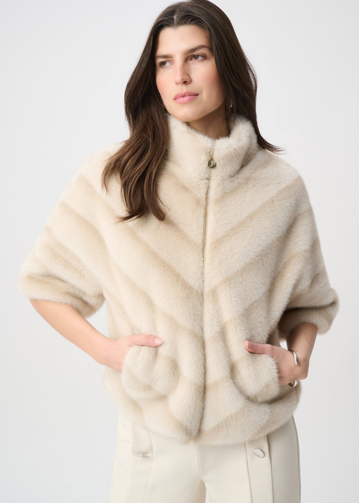 Woman wearing a cream-colored fur vest on a white background