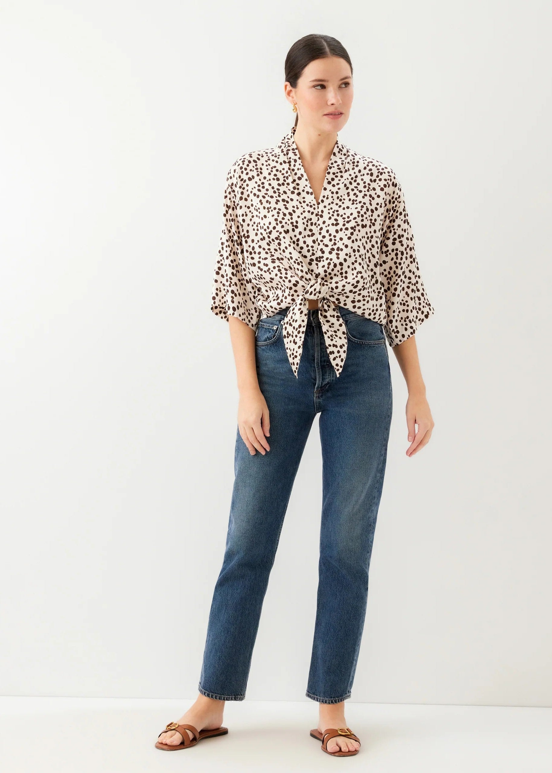 Woman wearing a leopard print scarf and blue jeans on a white background