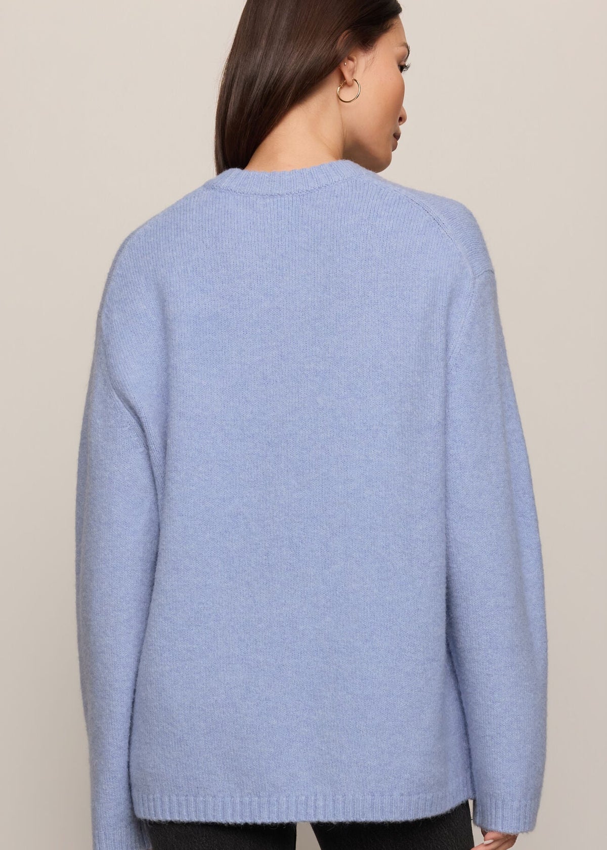 Person wearing a light blue sweater against a beige background