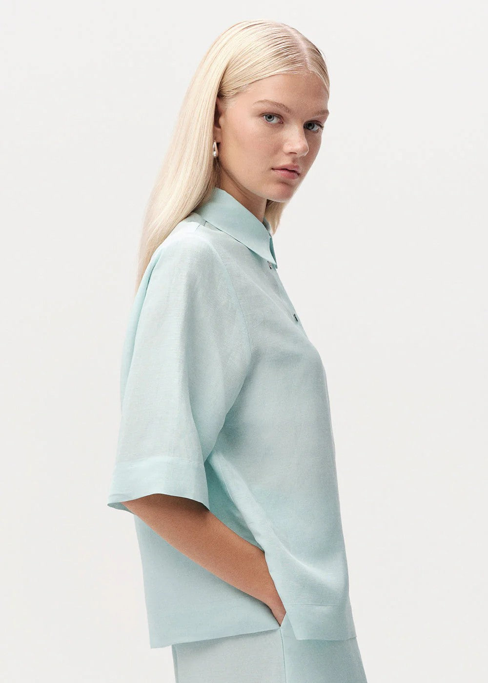 Woman wearing a light blue outfit on a plain background