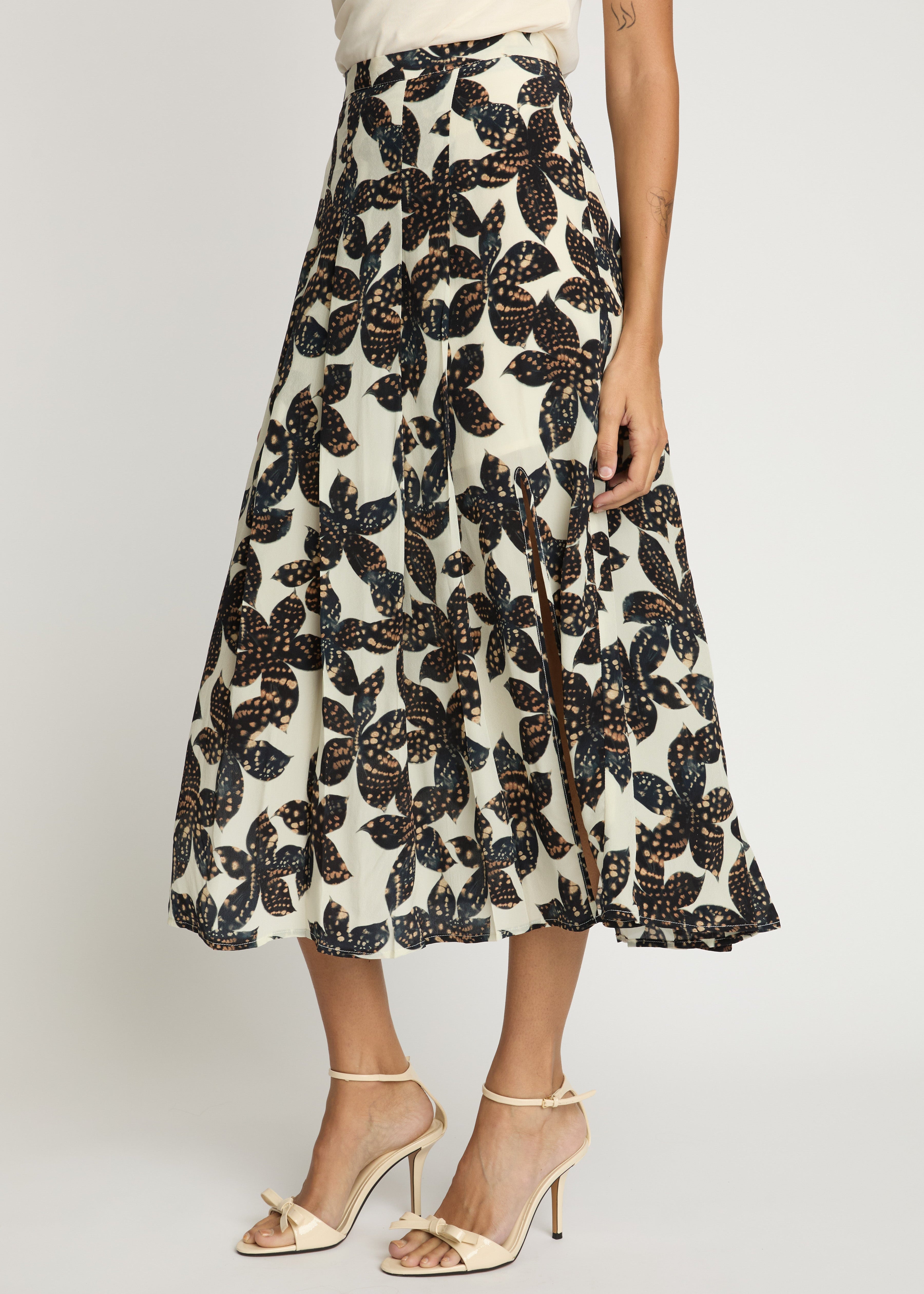 Person wearing a floral patterned skirt on a plain background