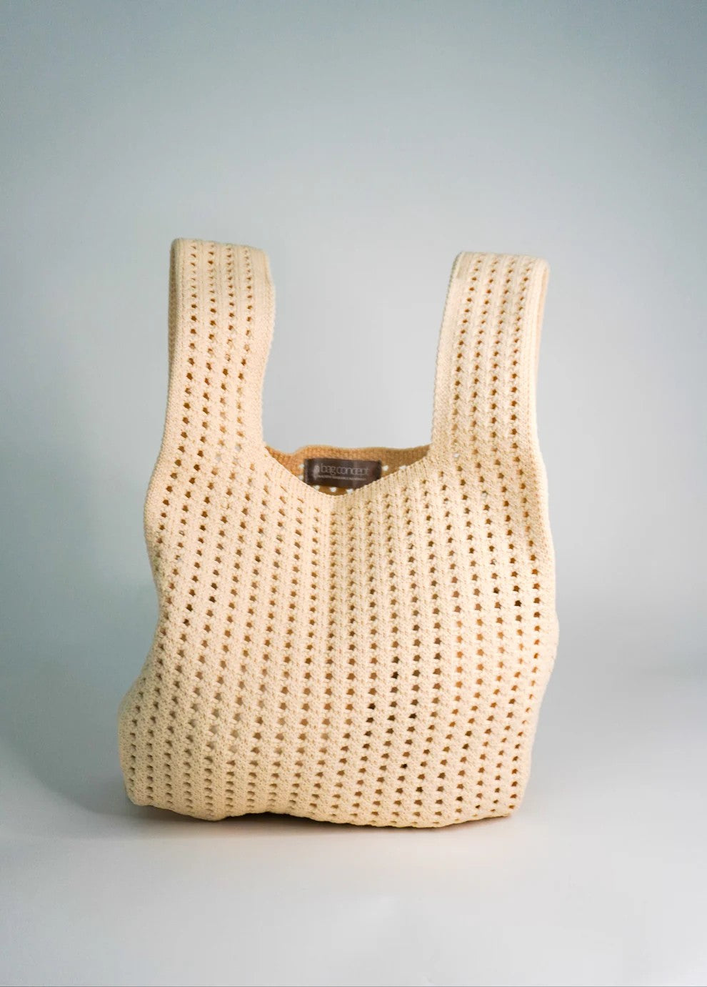 Beige woven handbag on a light gray background