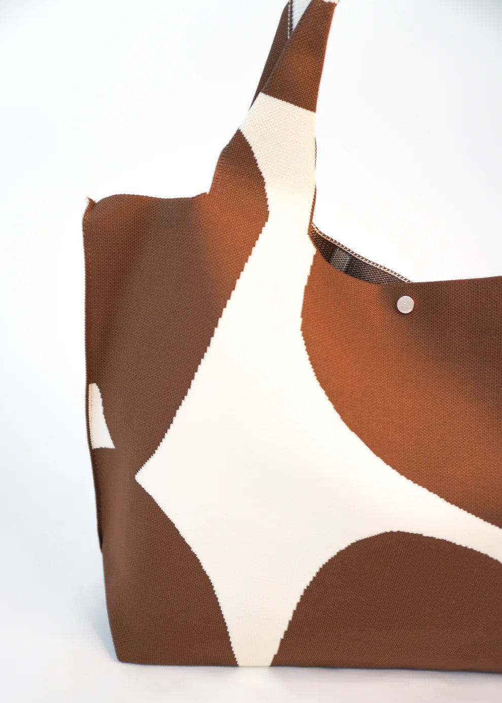 Brown and white patterned tote bag on a white background