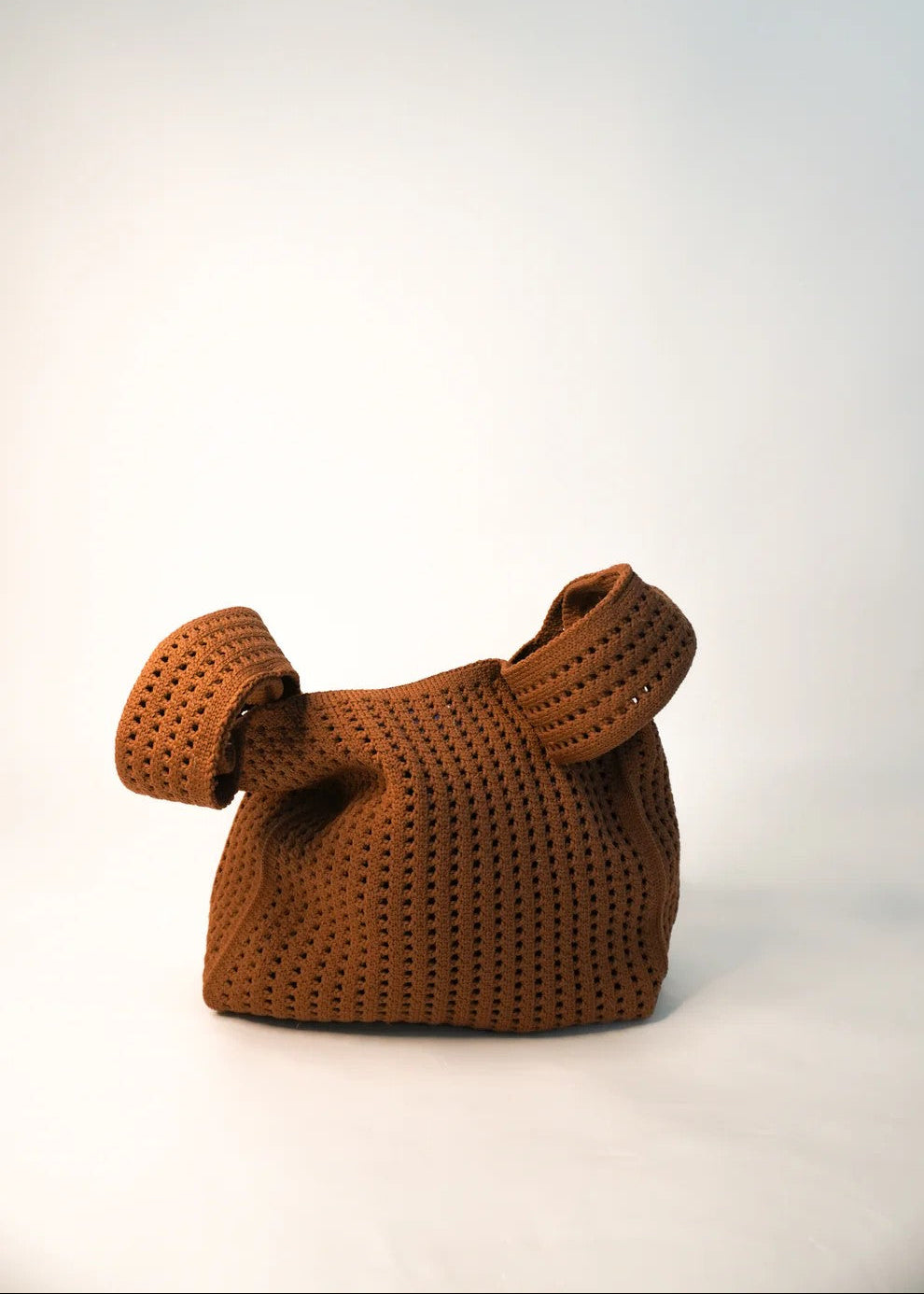 Brown woven handbag on a white background