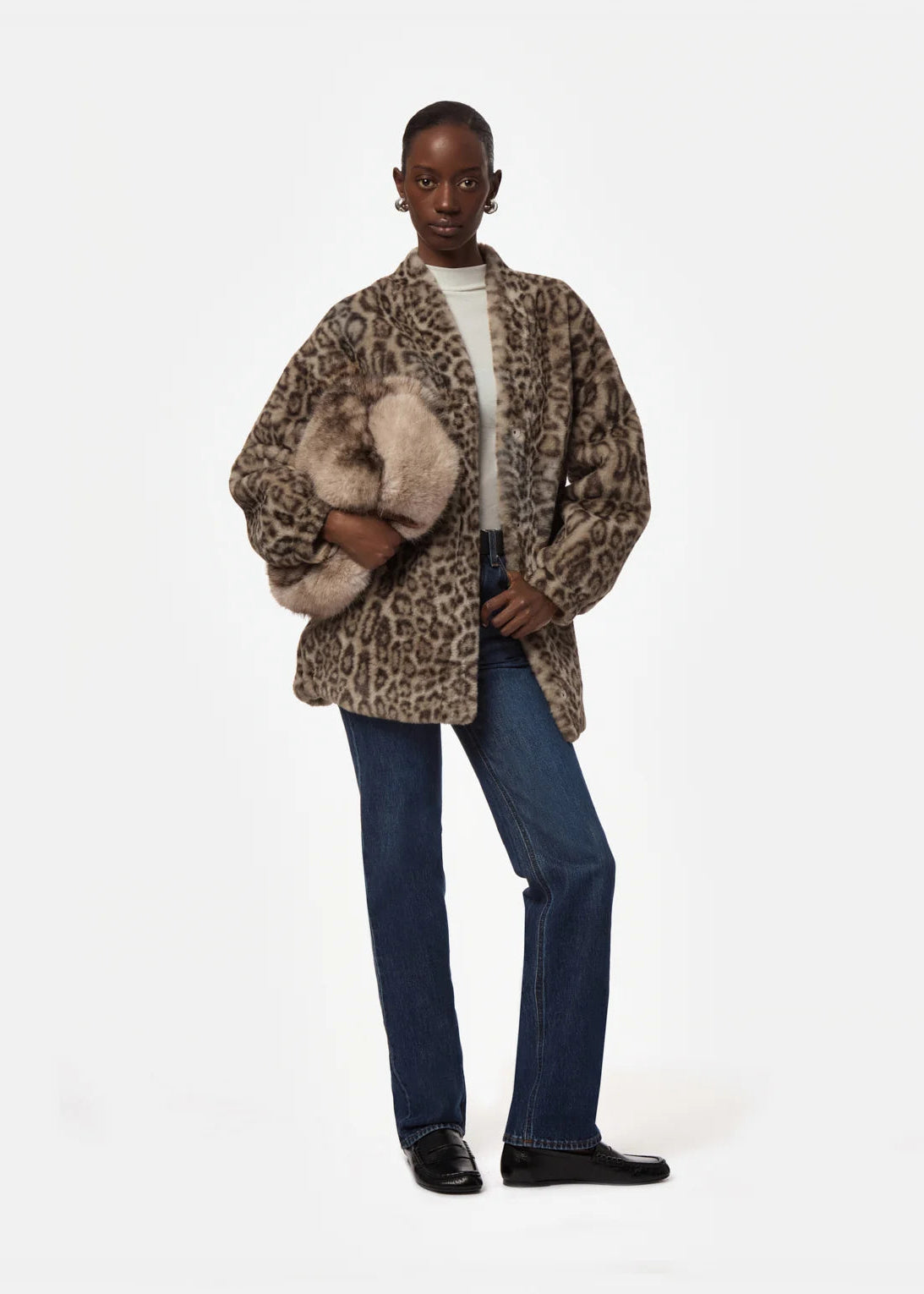Person wearing a leopard print coat with fur trim on a white background