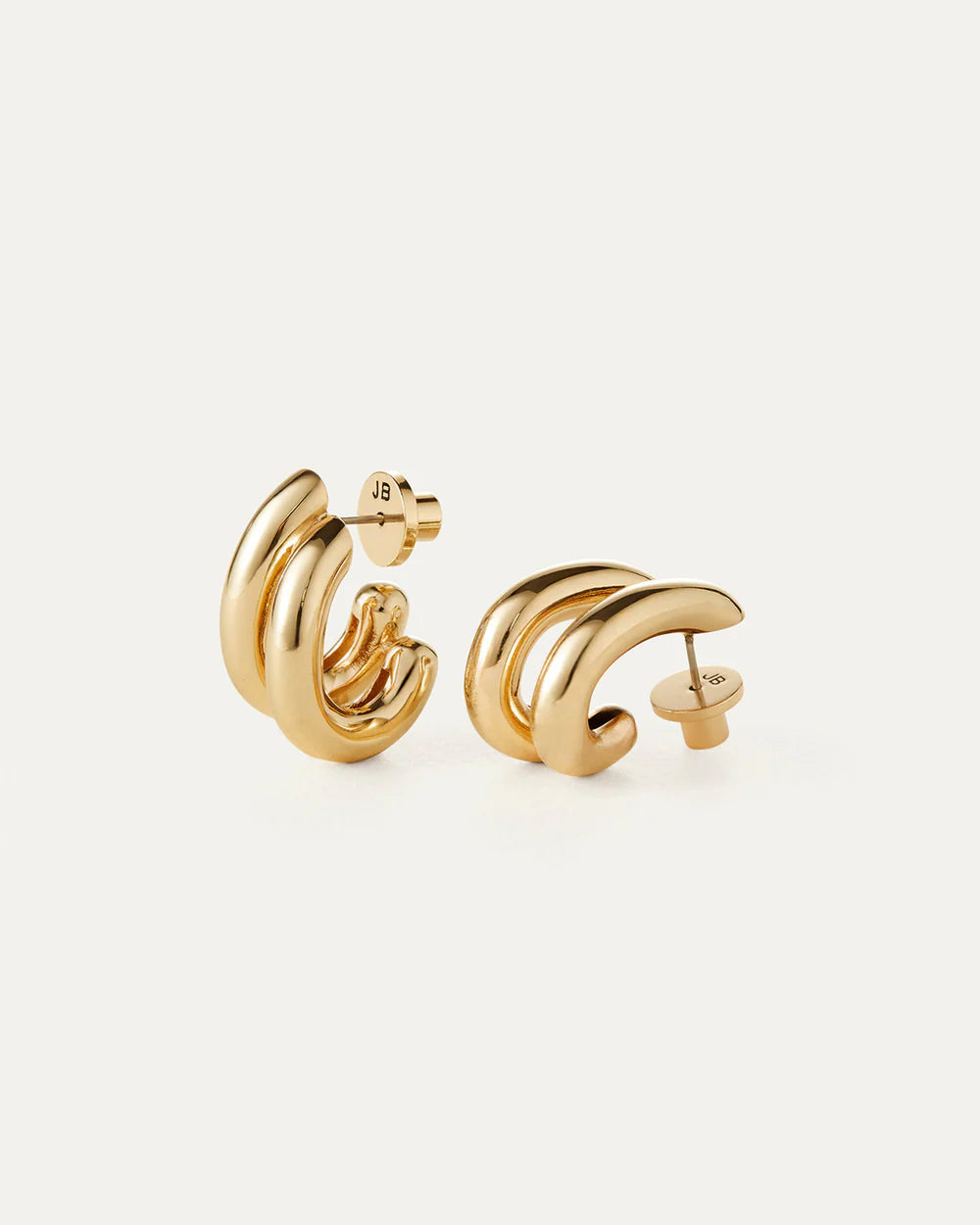 Pair of gold hoop earrings on a light beige background