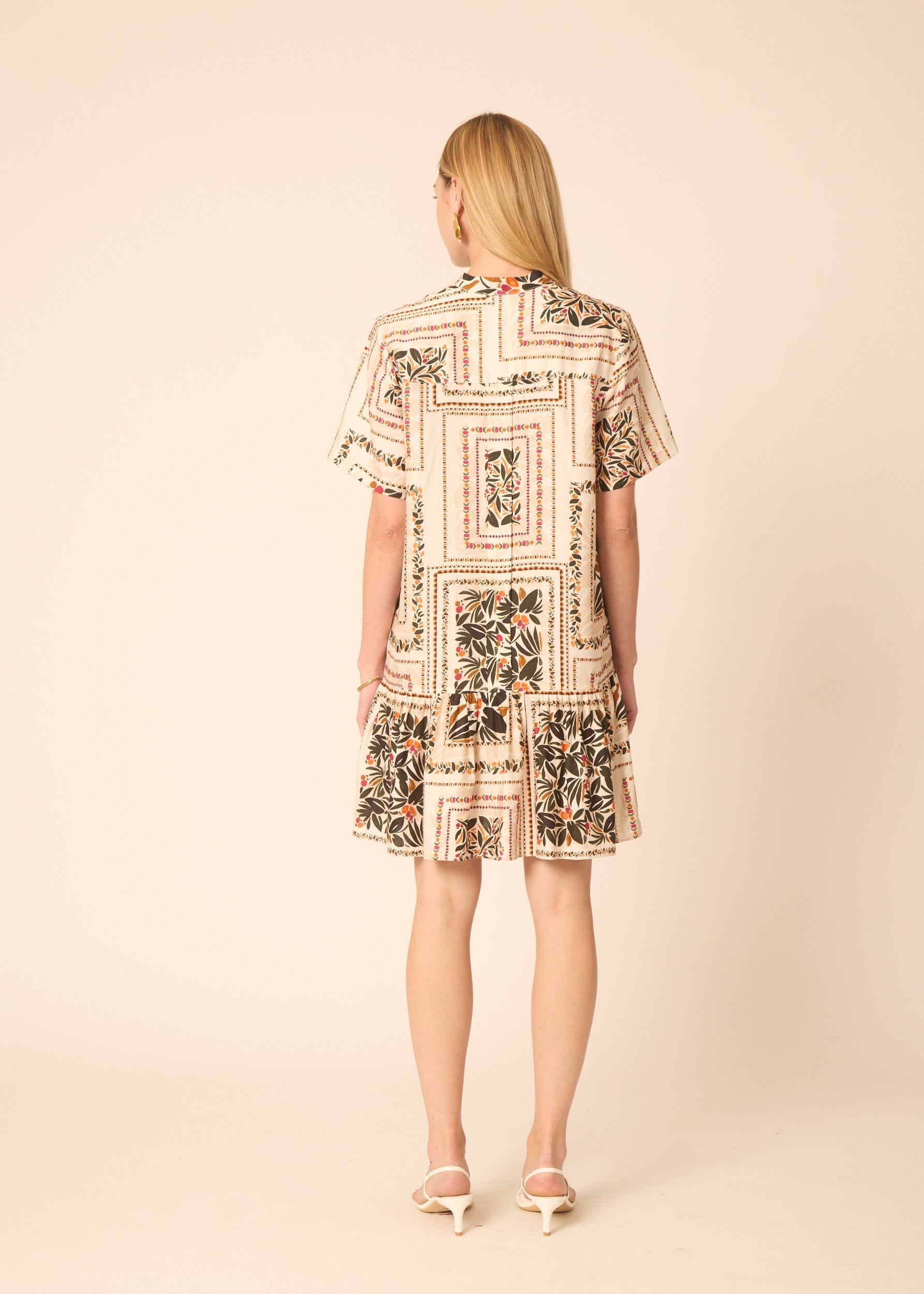 Woman wearing a floral dress on a beige background