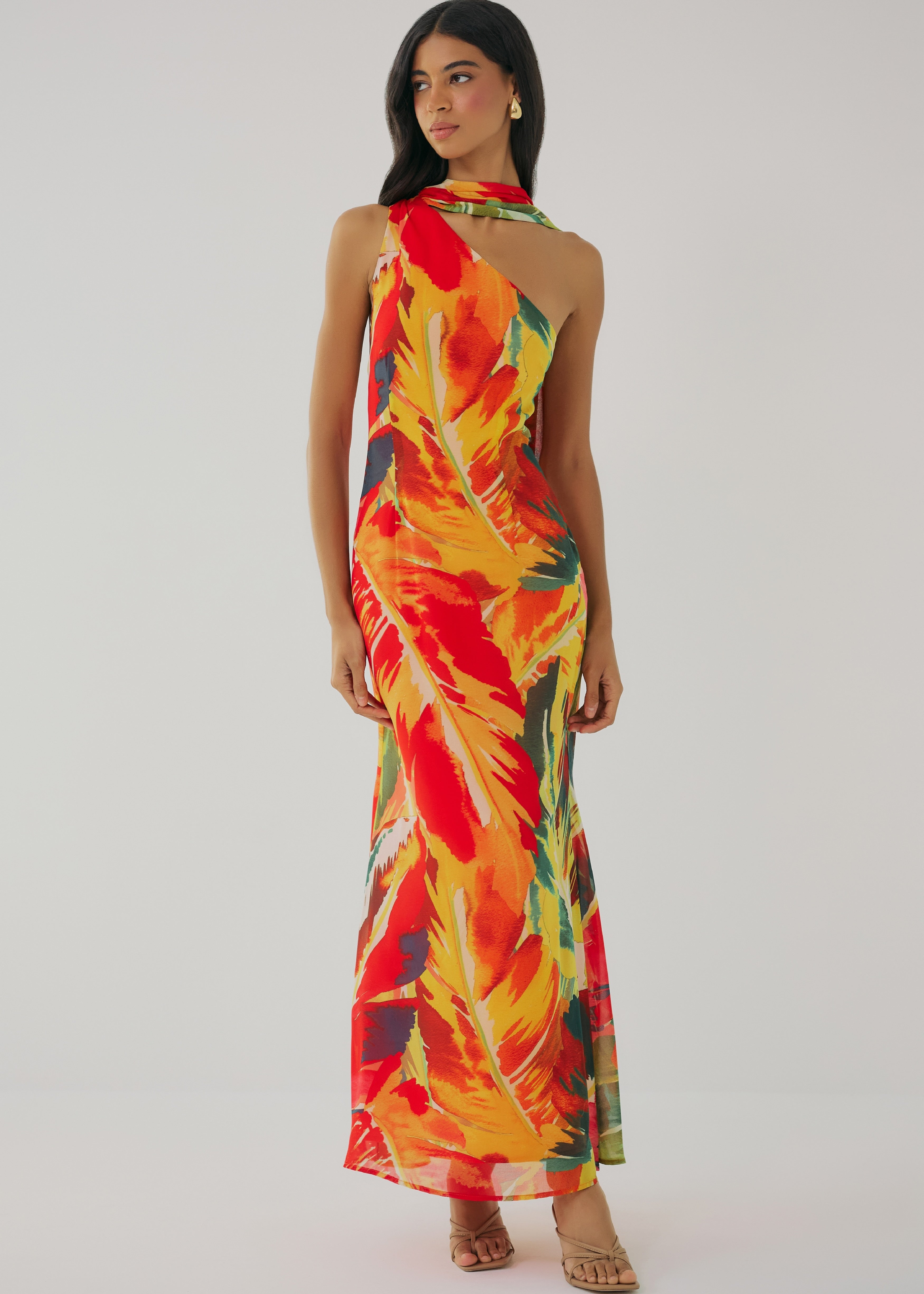 Woman wearing a colorful halter neck dress on a plain background