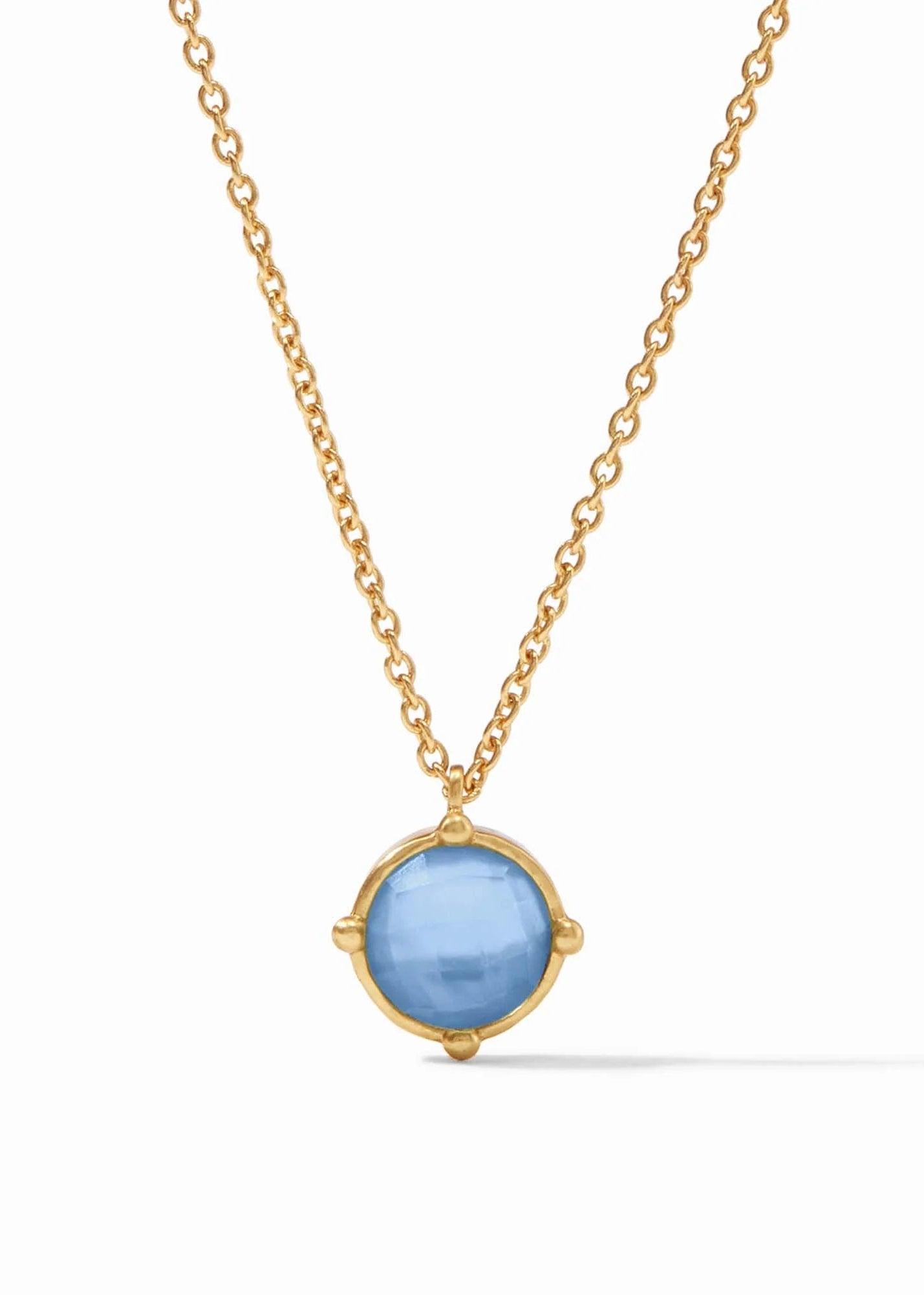 Gold necklace with a blue pendant on a white background