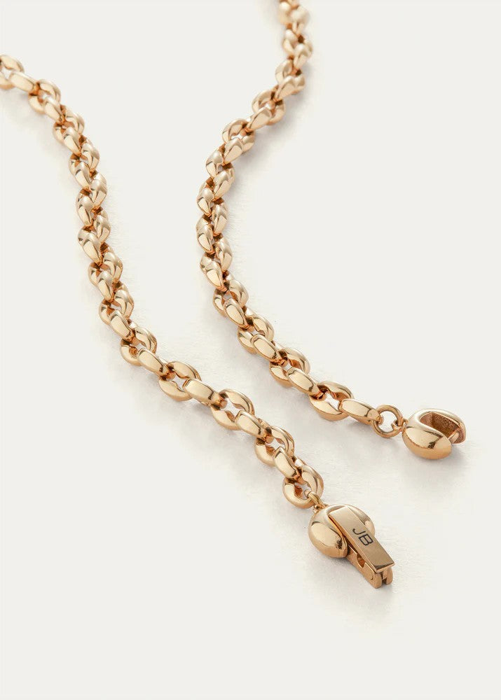 Rose gold chain necklace with a small pendant on a light beige background