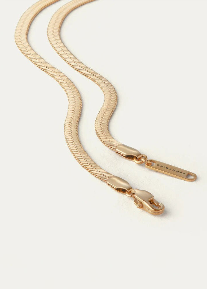 Gold chain with clasp on a light beige background