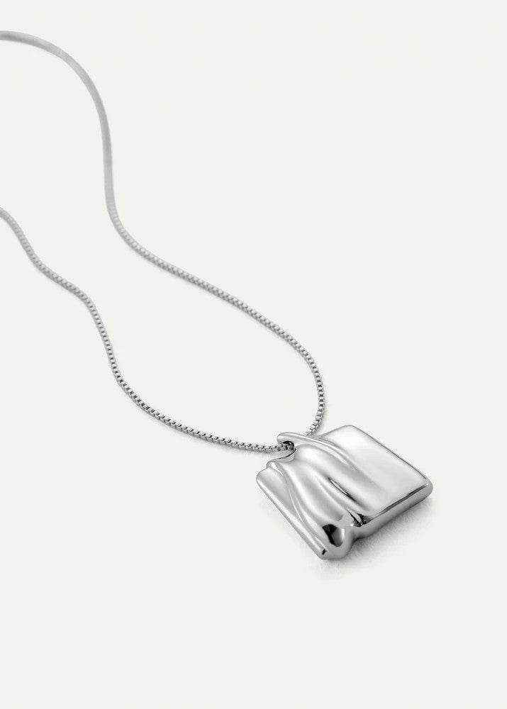 Silver necklace with a rectangular pendant on a light gray background
