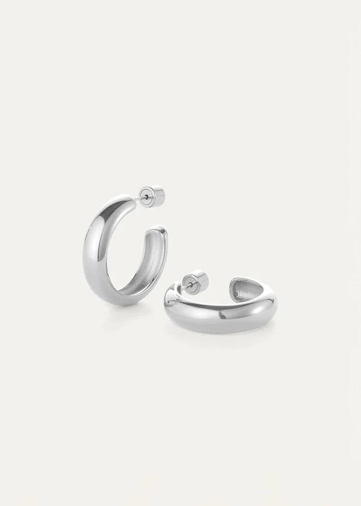 A pair of polished silver hoop earrings shown on a clean, light off-white background.