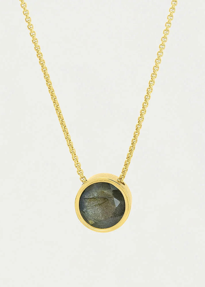 A gold chain necklace with a round bezel-set labradorite pendant on a light gray background.