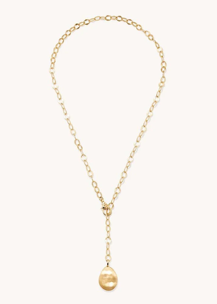 A delicate gold chain necklace with a long drop pendant, featuring a small gold bead at the bottom, displayed on a clean off-white background.