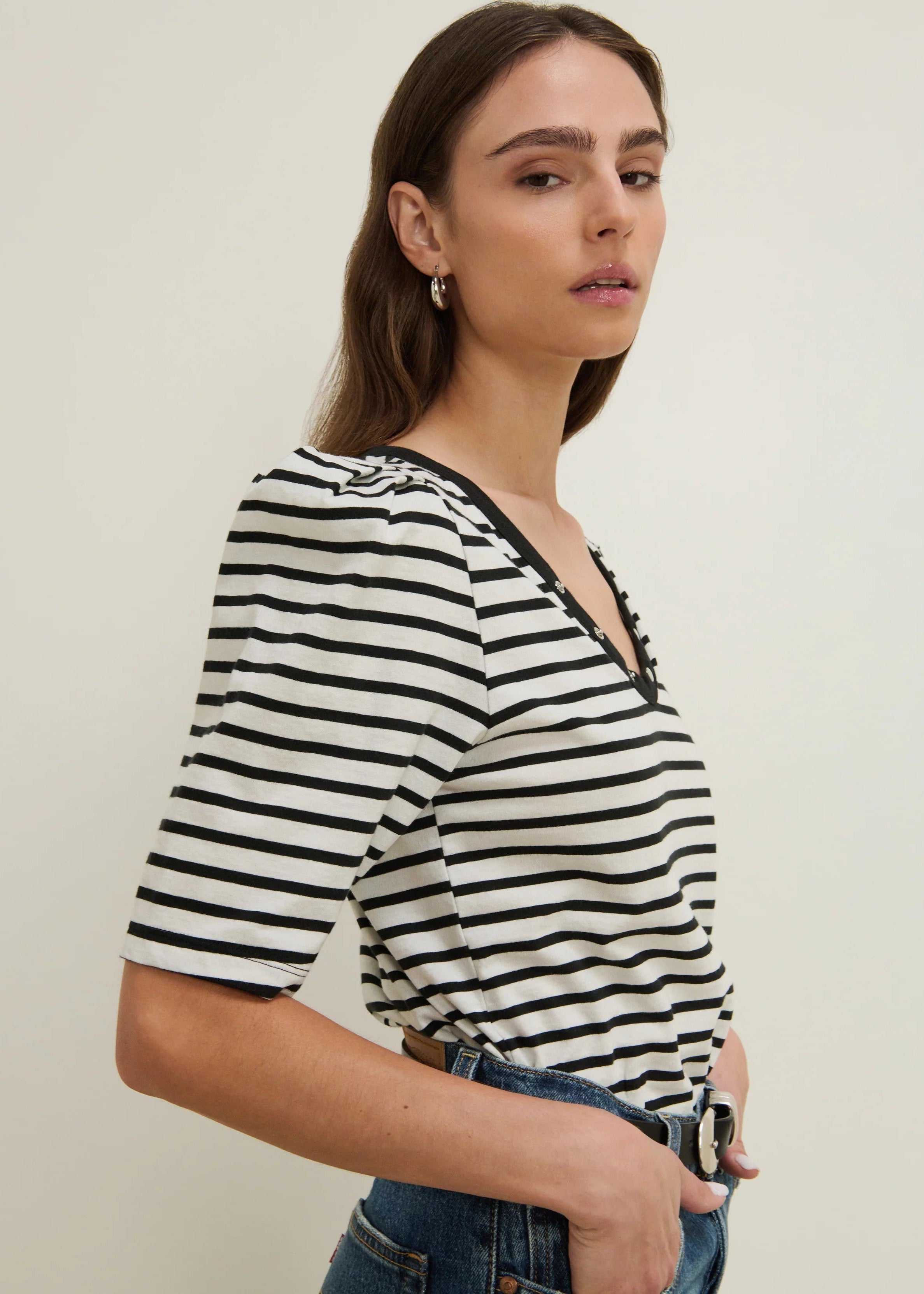 Woman wearing a black and white striped shirt with a plain background