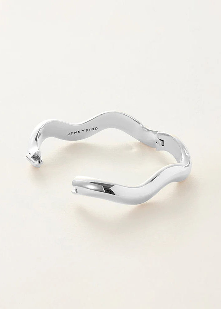 Silver bracelet with 'Jenny Bird' engraving on a light beige background