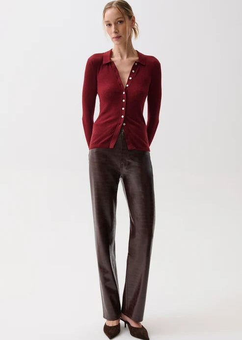 A woman modeling a dark red long-sleeve button-front top and dark brown wide-leg trousers against a plain light gray studio background.