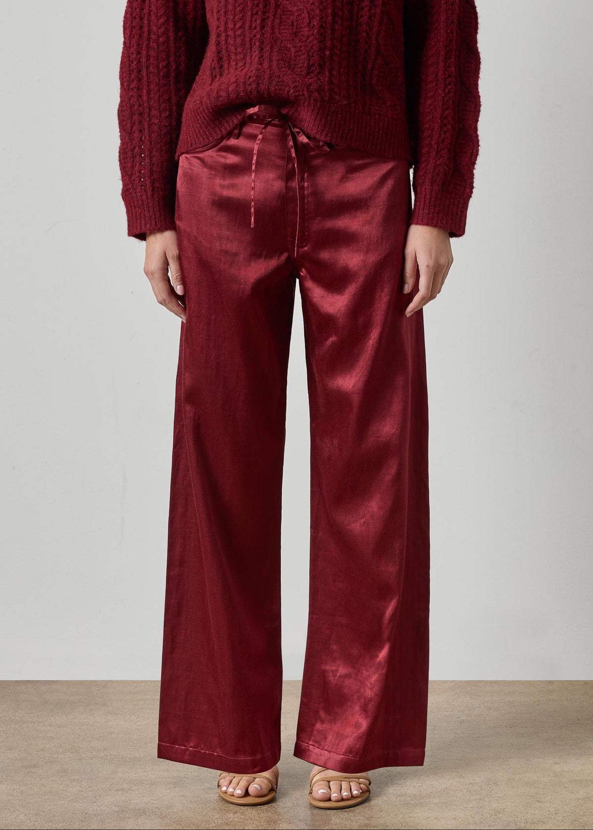 Person wearing a red sweater and red pants against a plain background