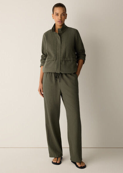 Person wearing an olive green outfit against a plain background