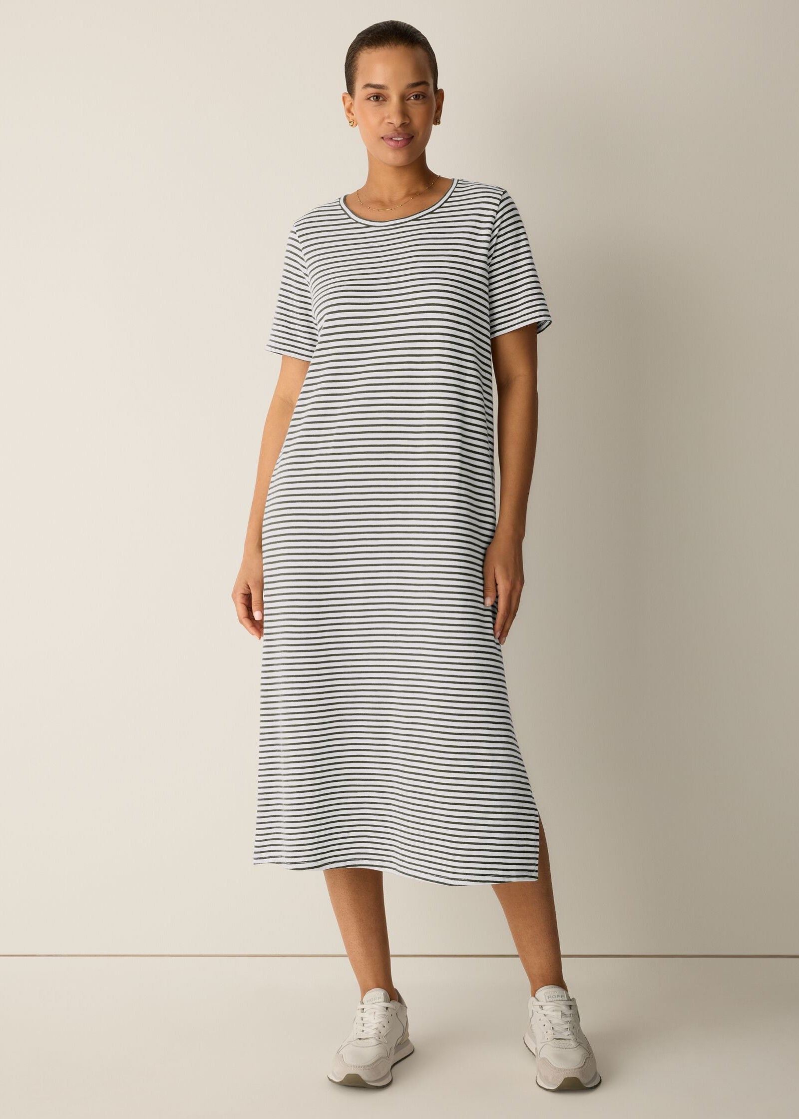 Woman wearing a striped dress on a plain background