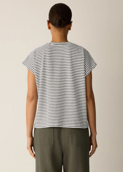 Person wearing a black and white striped shirt with a plain background