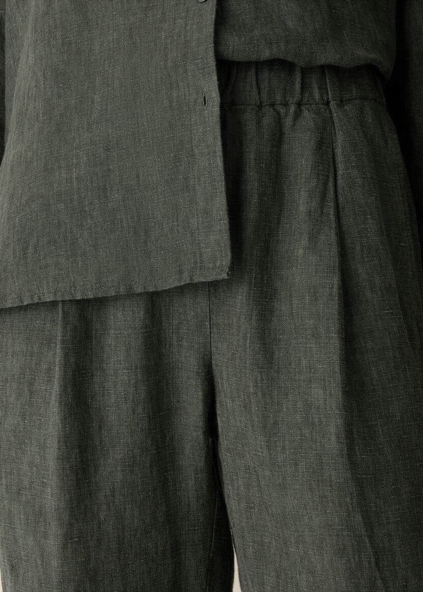 Dark gray layered outfit with a jacket and pants on a plain background