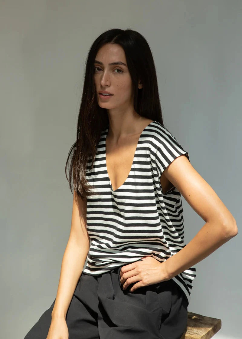 Woman wearing a black and white striped shirt against a gray background